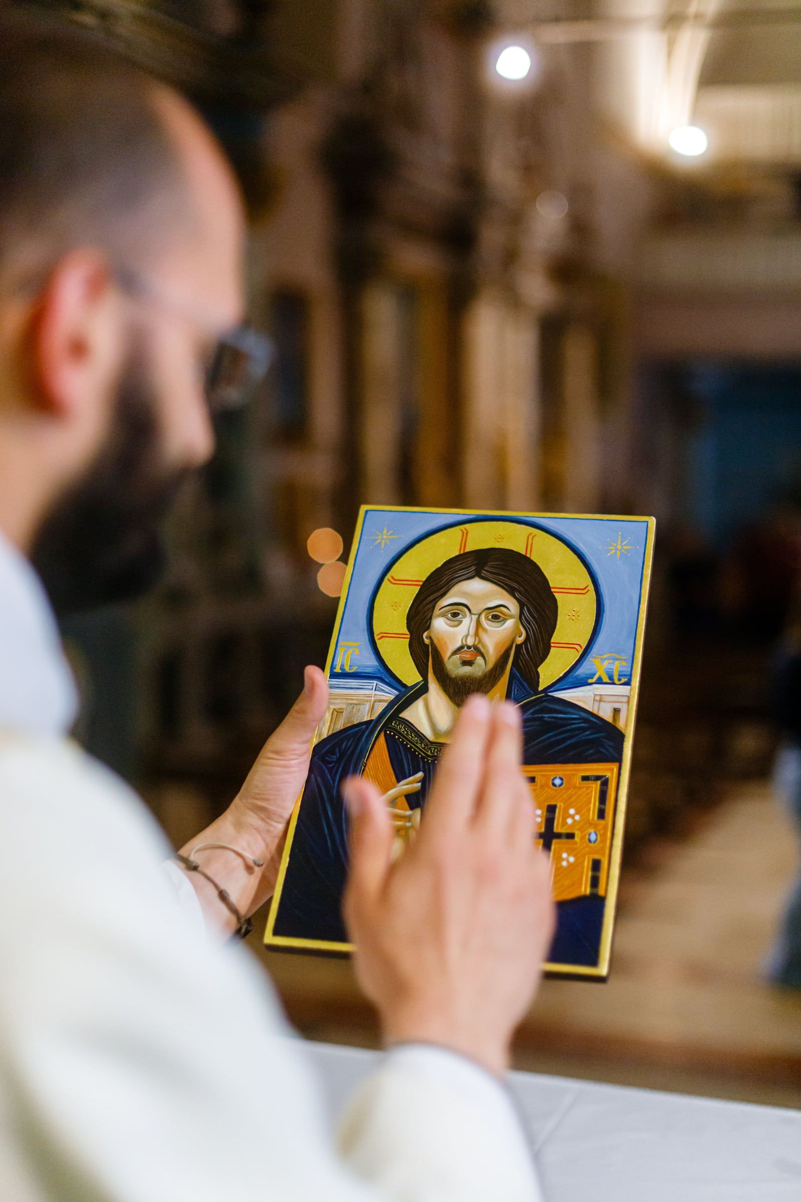 Un prêtre bénit une icône du Christ Pantocrator, dans une église