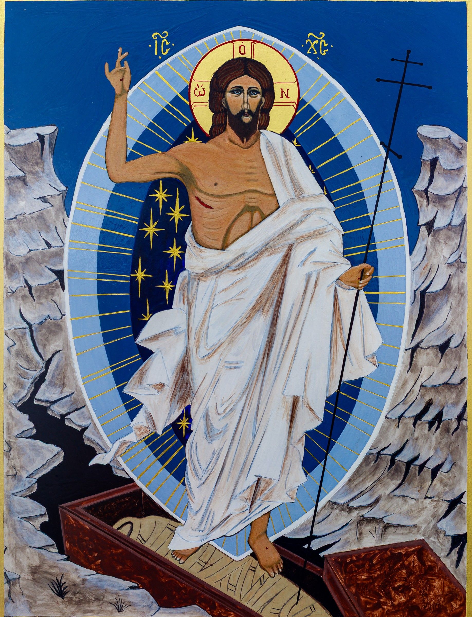 Icône de la Résurrection : le Christ vêtu de blanc, dans une mandorle bleue étoilée, tenant la croix et sortant du tombeau entre les rochers