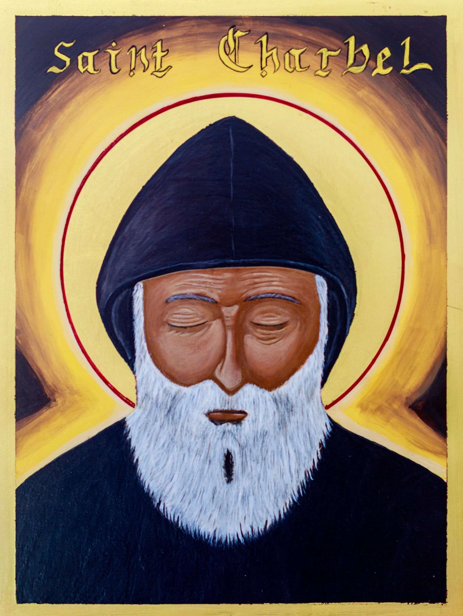 Icône de saint Charbel, moine en coule noire, barbe blanche, yeux baissés, inscription « Saint Charbel », fond d'or